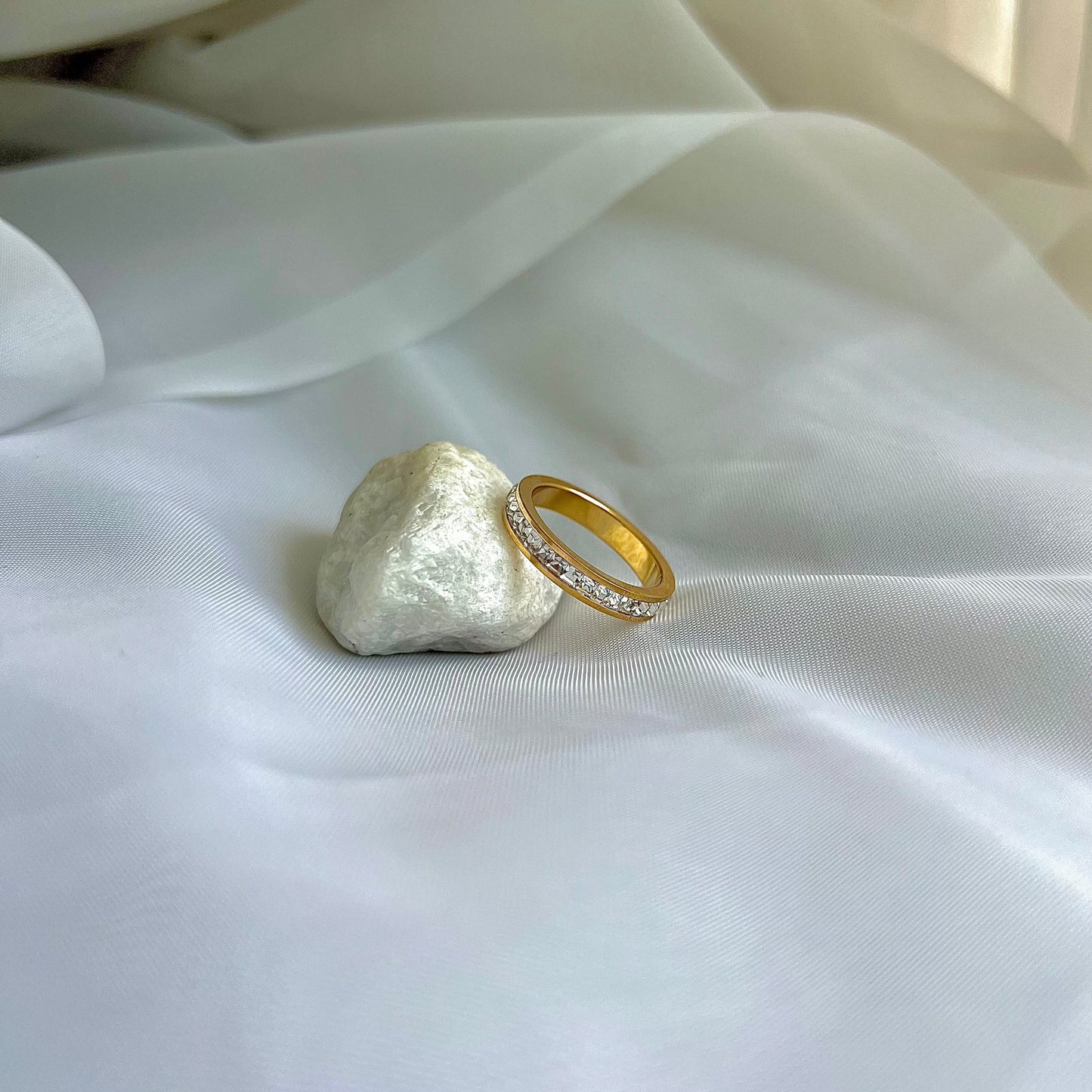 the Aurora ring, a gold band with sparkling diamonds, offering a timeless and elegant style.