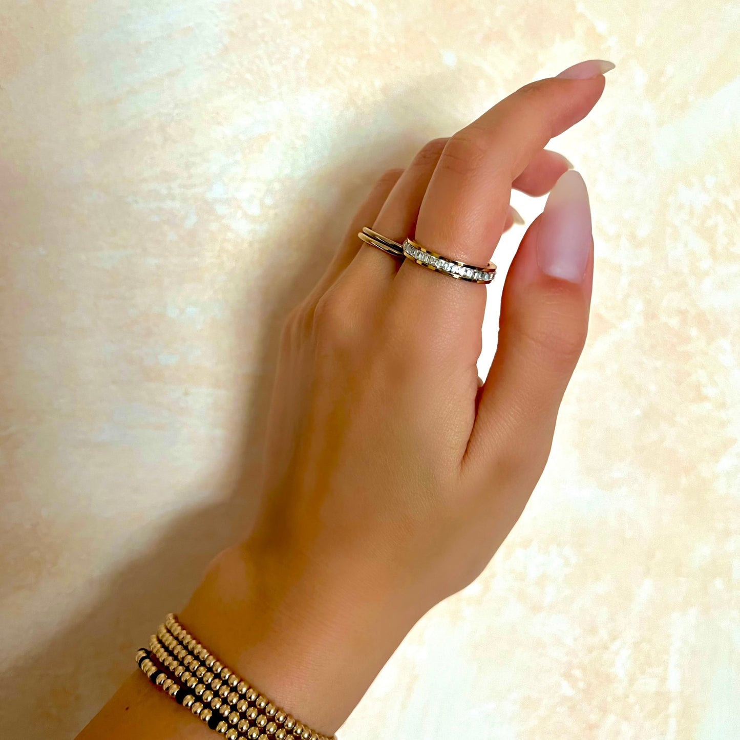 Woman wearing the Aurora ring, a gold-plated statement piece with a sleek, modern design.